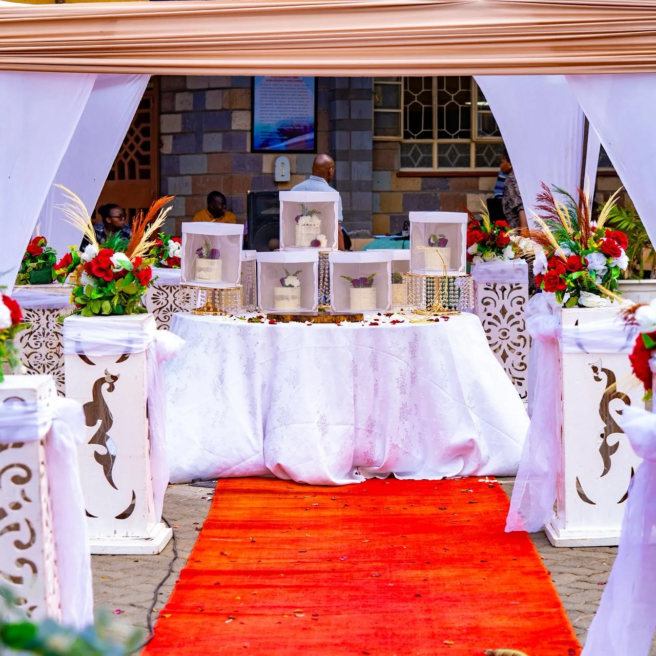 A tiered wedding cake dressed in fresh roses