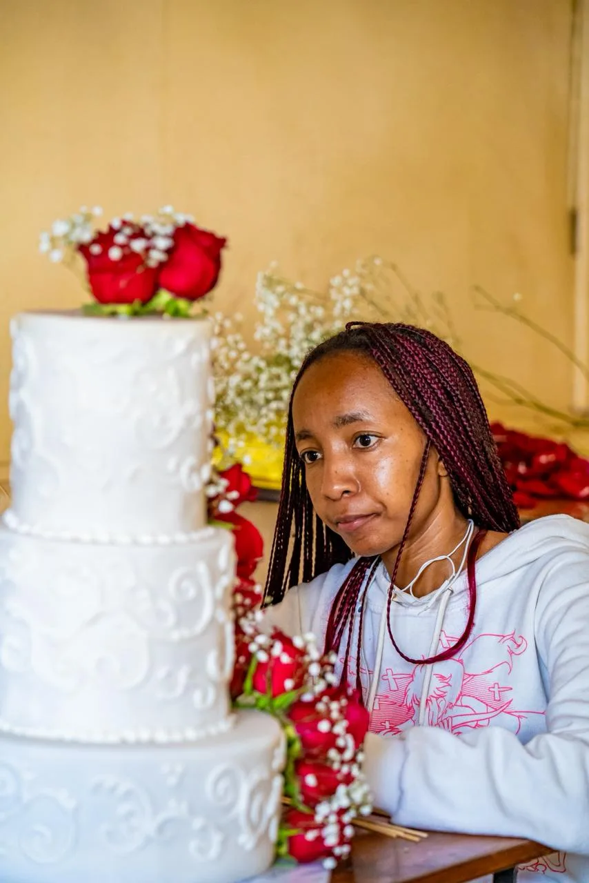 A tiered wedding cake dressed in fresh roses
