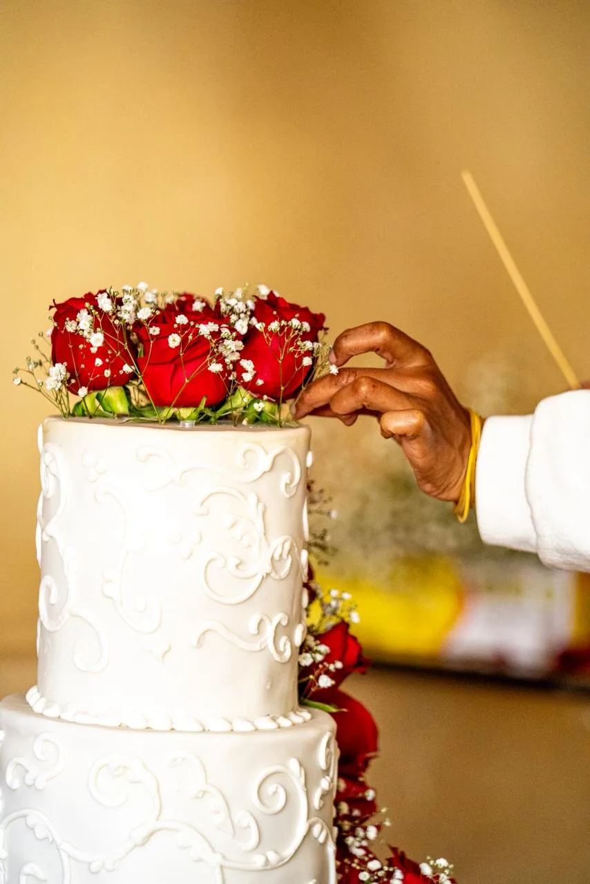 A tiered wedding cake dressed in fresh roses