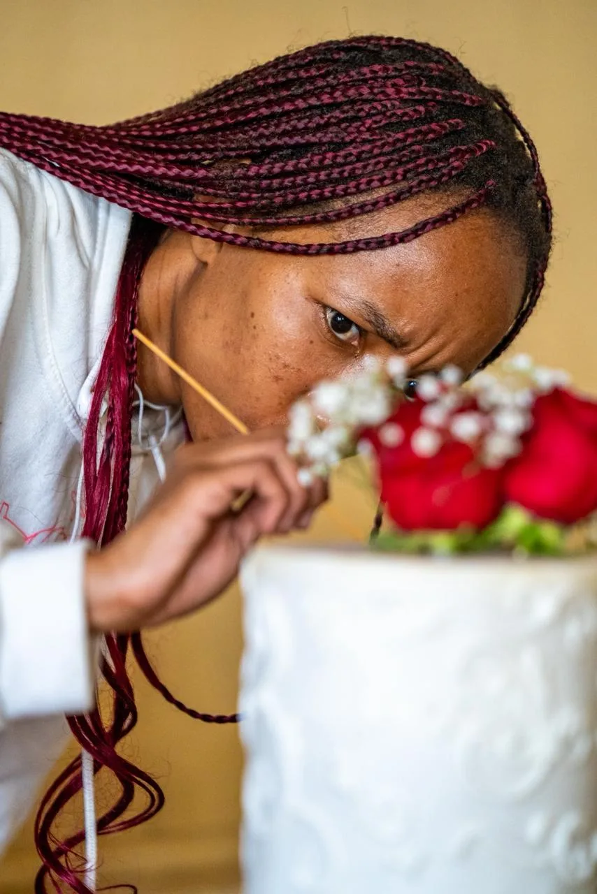 A tiered wedding cake dressed in fresh roses
