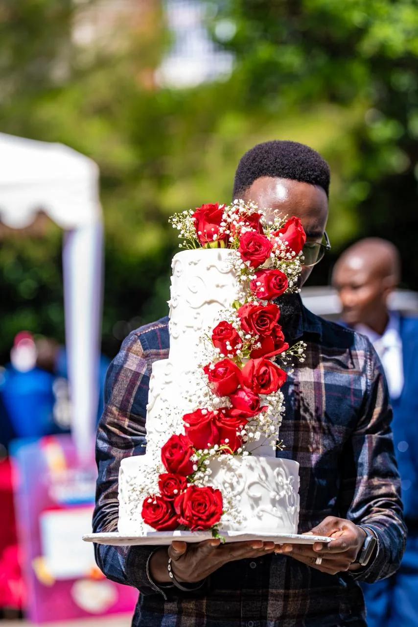 A tiered wedding cake dressed in fresh roses