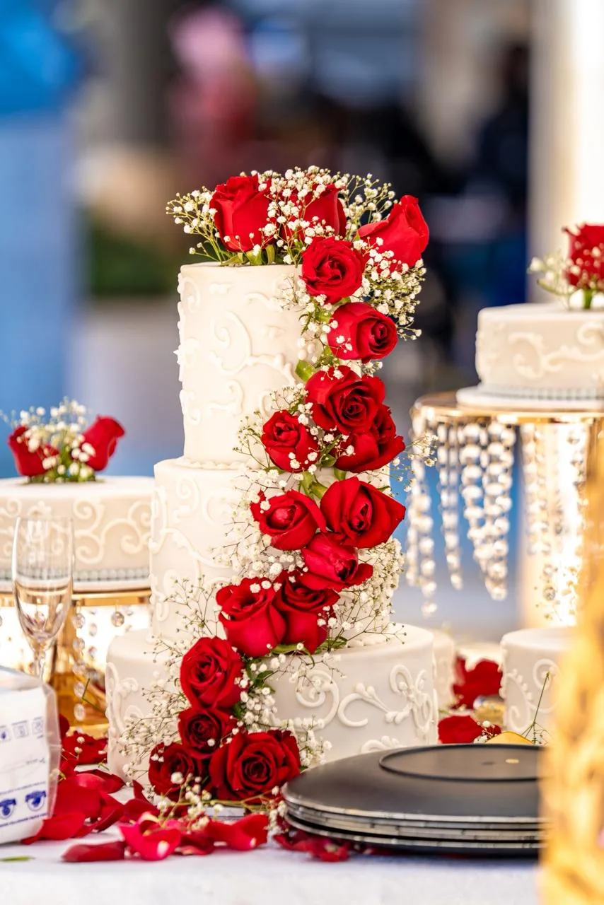 A tiered wedding cake dressed in fresh roses