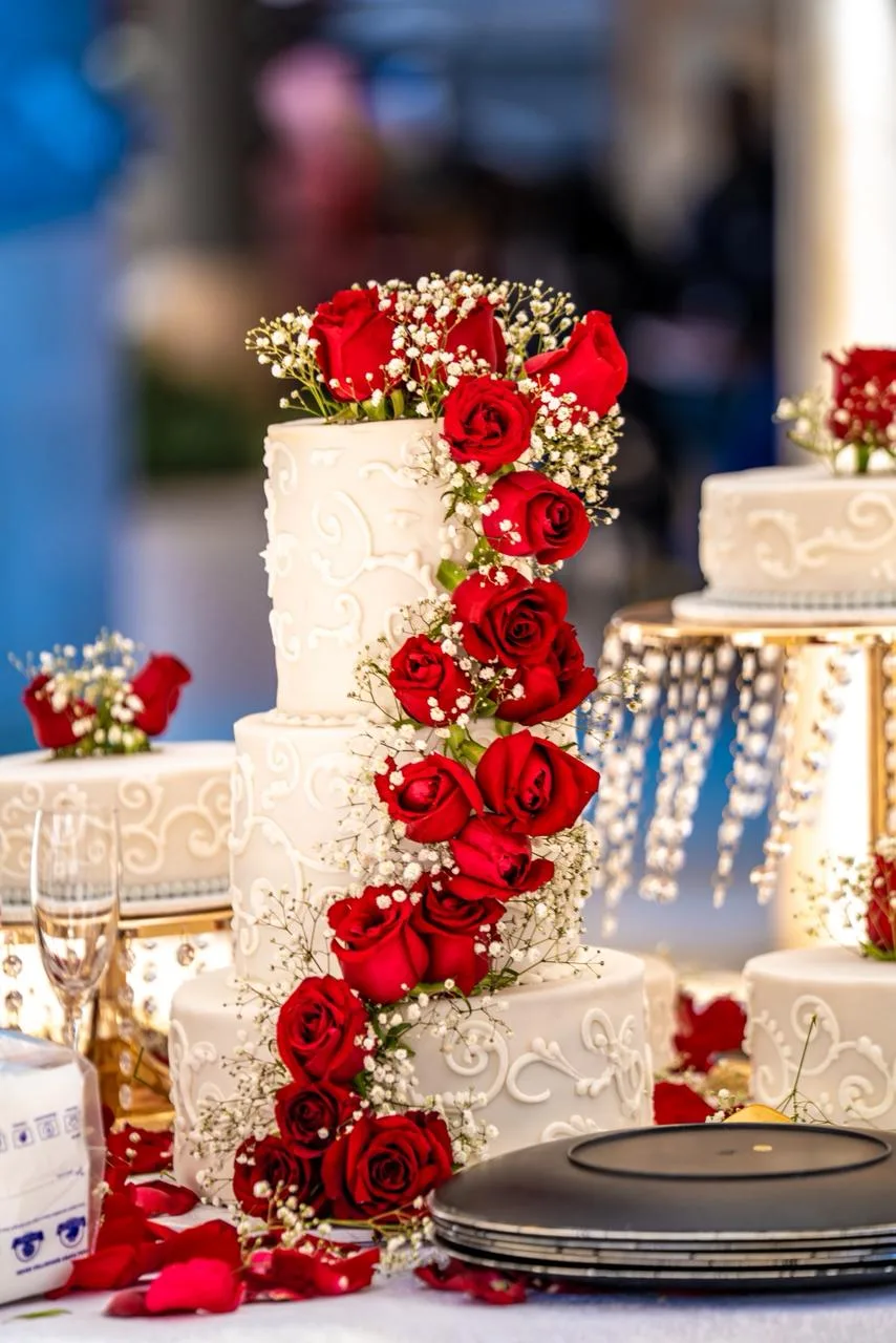 A tiered wedding cake dressed in fresh roses