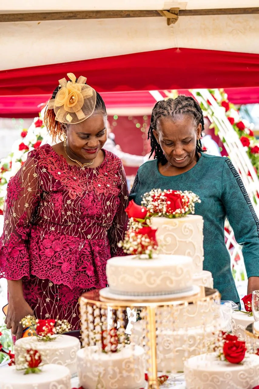 A tiered wedding cake dressed in fresh roses